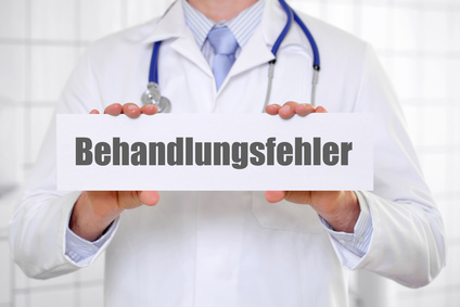Behandlungsfehler Mann im Arztkittel hält Schild mit der Aufschrift Behandlungsfehler