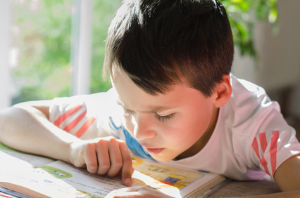 Keine Schulbegleitung für 8-Jährigen mit Herzkrankheit Kleiner Junge sitzt am Tisch und ließt ein Buch