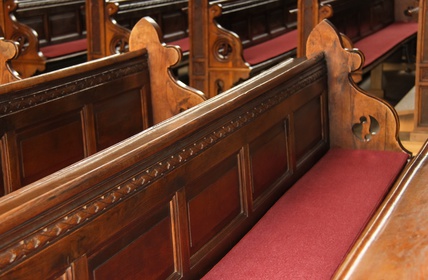 Klage gegen Kirchensteuer Kirchenbänke mit roten Polstern