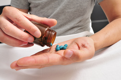 Mann mit Viagra Mann schüttet blaue Pillen auf seine Hand